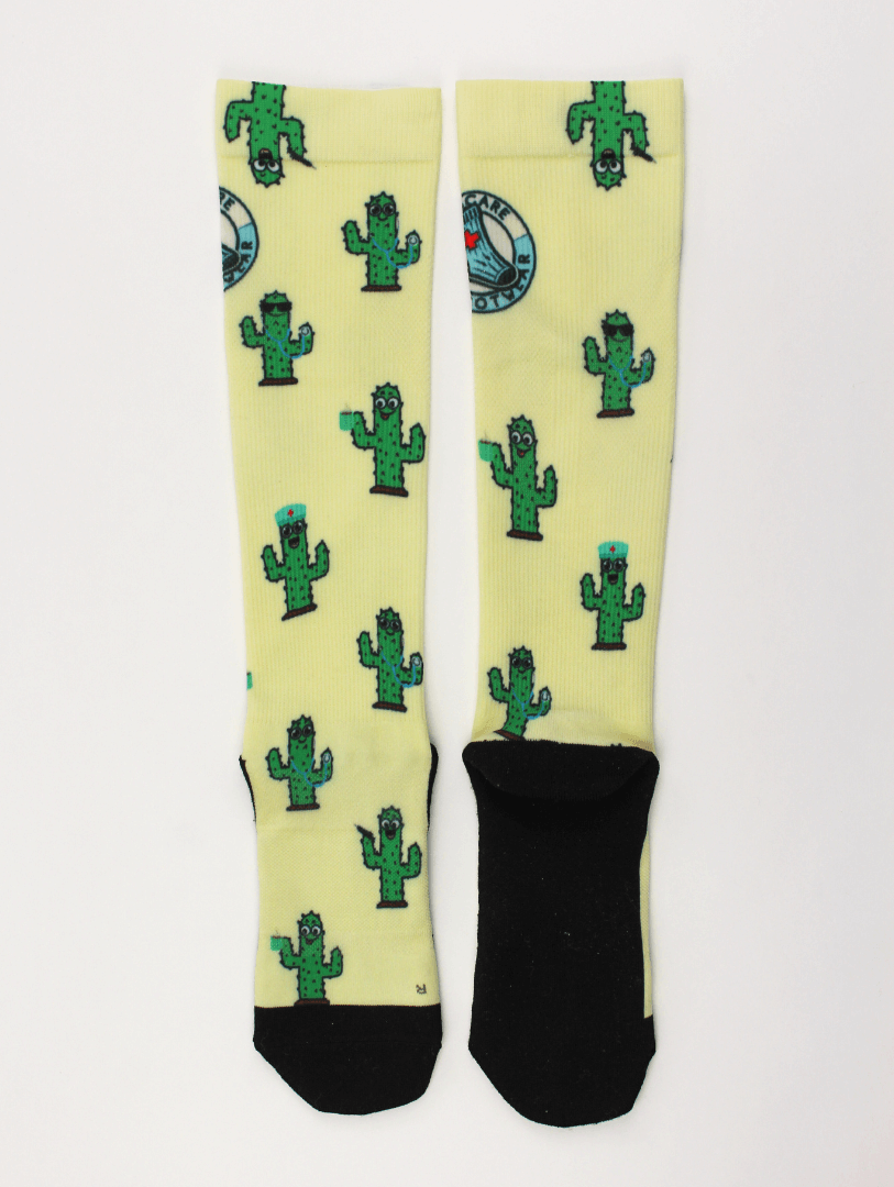 Compression socks for nurses with a cactus design, socks lying flat and facing back.