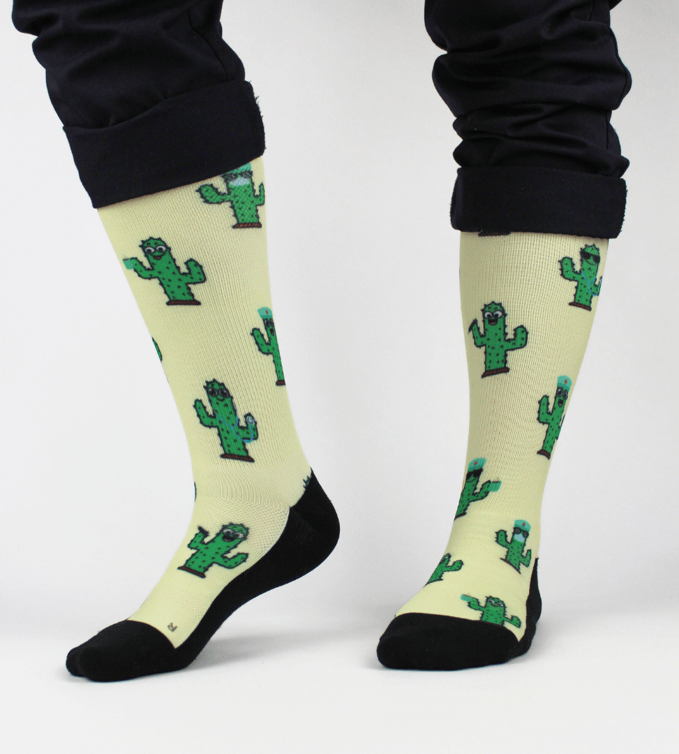 Compression socks for nurses with a cactus design, front view of whole socks on legs.