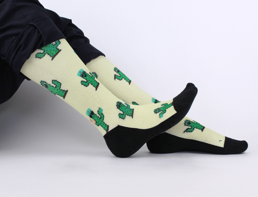 Compression socks for nurses with a cactus design, landscape view of whole socks on legs.