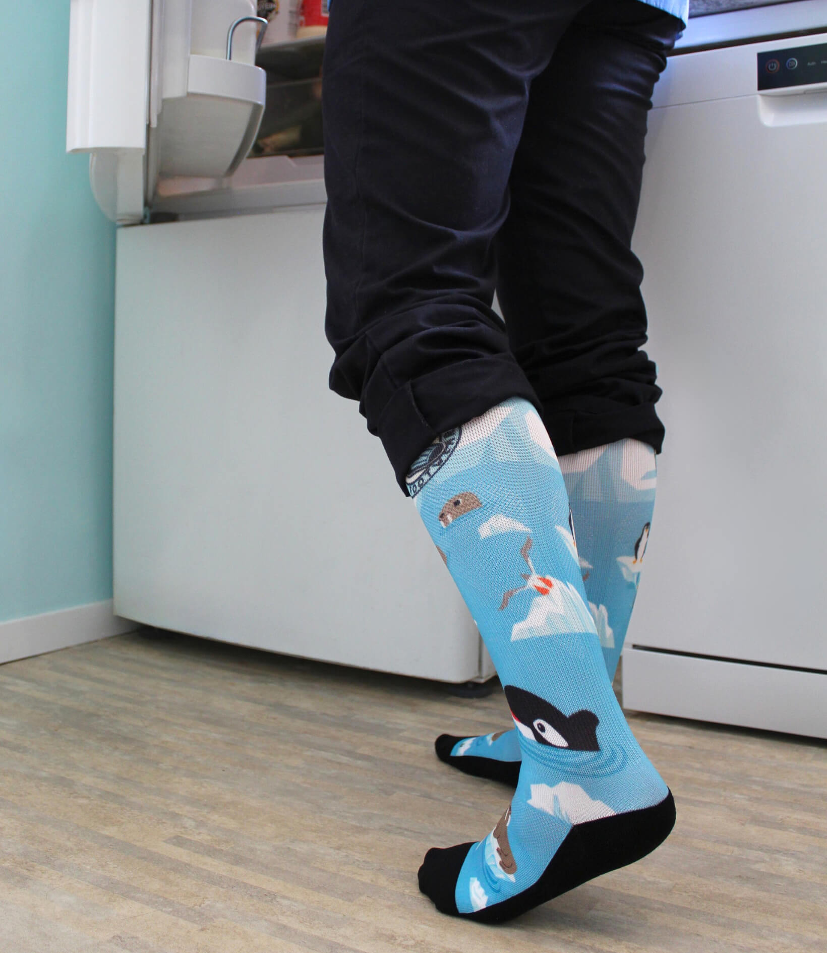 Scrubcare Footwear's polar nursing socks on nurse in scrubs who is opening a fridge.